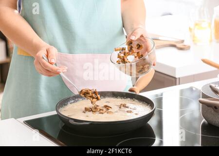 Frau Kochen Risotto in der Küche Stockfoto