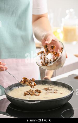 Frau Kochen Risotto in der Küche Stockfoto