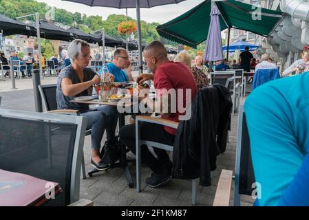 Leute essen auswärts und essen traditionelle Muschel und pommes Gericht Moules et Frites in Dinant Stockfoto