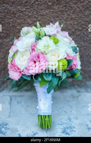 Brautstrauß aus rosa Blumen, weiße Blumen auf dem braunen und grauen Hintergrund Stockfoto