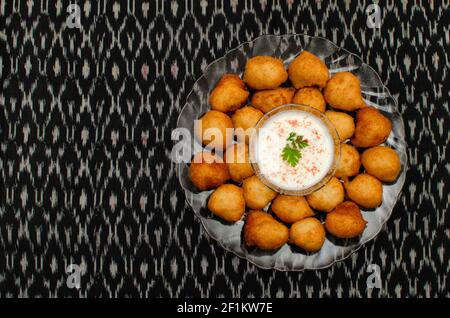 Dahi Wada, berühmtes indisches Street Food oder Snacks in transparentem Farbteller auf schwarzem Hintergrund Stockfoto