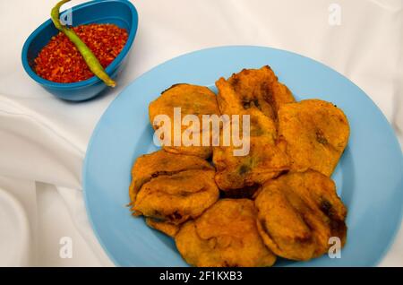 Batata Wada, berühmte Maharashtrian Street Food, Kartoffeln mit Gramm Mehl bedeckt, frittiert und mit würzigem Knoblauch-Chutney-Pulver serviert Stockfoto