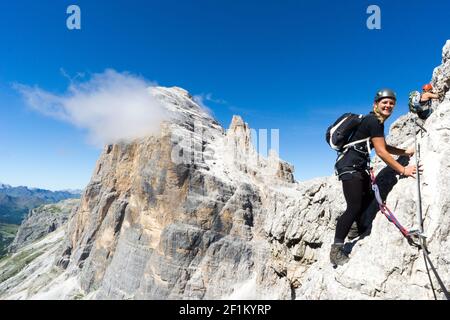 Junge attraktive blonde Bergsteigerin in den Dolomiten Italien Stockfoto