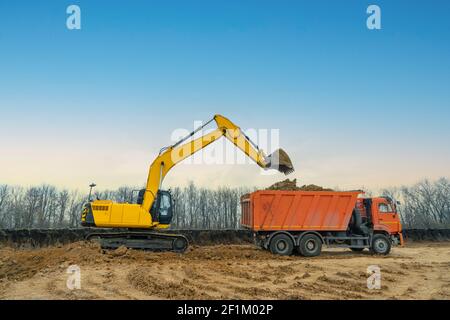 Ein großer Baubagger von gelber Farbe auf der Baustelle in einem Steinbruch für den Abbau. Industriebild Stockfoto