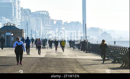 Brighton UK 9th March 2021 - Läufer und Wanderer machen das Beste aus einem schönen sonnigen Morgen an der Küste von Hove, da das Wetter in den nächsten Tagen in ganz Großbritannien regnerisch und stürmisch sein wird : Credit Simon Dack / Alamy Live News Stockfoto