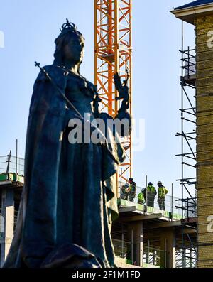 Brighton UK 9th March 2021 - Bauherren in der Sonne auf dem Dach eines Gebäudes bei der Queen Victoria Statue an der Küste von Hove als nasses und stürmisches Wetter wird in den nächsten Tagen in ganz Großbritannien ankommen prognostiziert : Credit Simon Dack / Alamy Live News Stockfoto