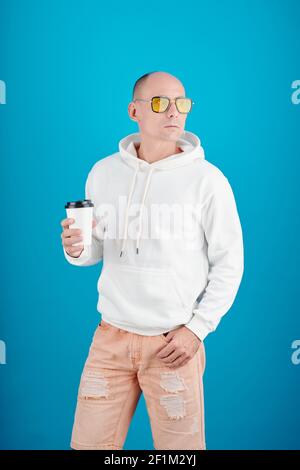Portrait von selbstbewussten reifen Mann in Sonnenbrille hält Tasse Kaffee mitnehmen und wegschauen Stockfoto
