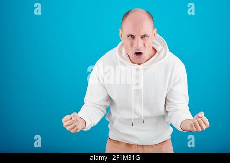 Portrait von wütend emotionalen reifen Mann in weißen Hoodie schreien Und Blick auf die Kamera Stockfoto
