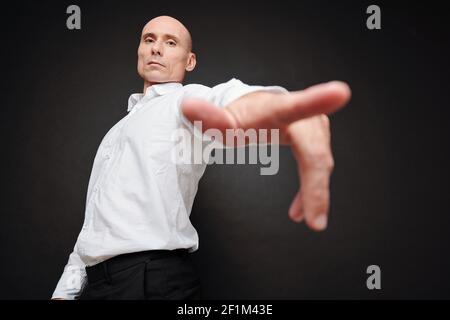 Selbstbewusster reifer Politiker, der nach unten schaut und auf die Kamera zeigt Stockfoto