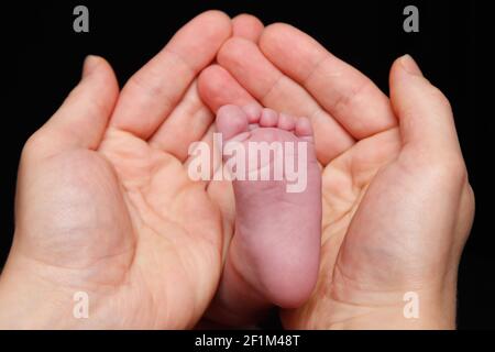 Neugeborenes Baby Füße in die Hand des Vaters Stockfoto