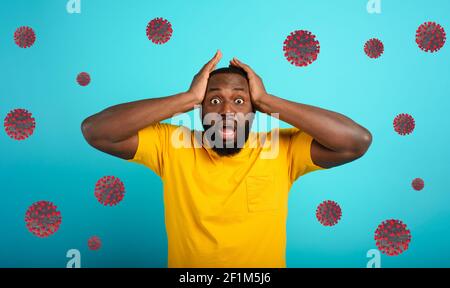 Ängstlicher Ausdruck eines Jungen, der Angst hat, das Coronavirus zu fangen. Hintergrund Zyan. Stockfoto