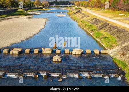 Menschen laufen auf Schildkröten Trittsteinen des kamo Flusses, kyoto, japan Stockfoto