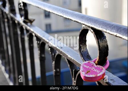 Herzförmiges Vorhängeschloss hängt an den Riegel eines Zauns, um ewige Liebe auszudrücken. Montmartre, Paris, Frankreich Stockfoto