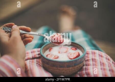 Erdbeeren mit Milch essen Stockfoto