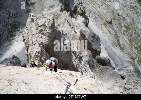 Bergsteiger auf einer steilen und exponierten Felswand klettern A Via Ferrata Stockfoto