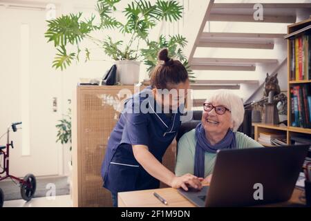 Ältere Frau und Pflegekraft mit Laptop Stockfoto