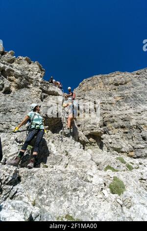 Bergführer und mehrere Kunden besteigen einen Klettersteig in Die italienischen Dolomiten Stockfoto