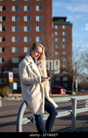Junge Frau mit Smartphone auf der Straße Stockfoto