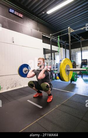 Mann Gewichtheben in der Turnhalle Stockfoto
