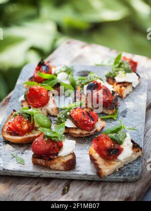 Canapes mit gegrillten Kirschtomaten und Ricotta Stockfoto