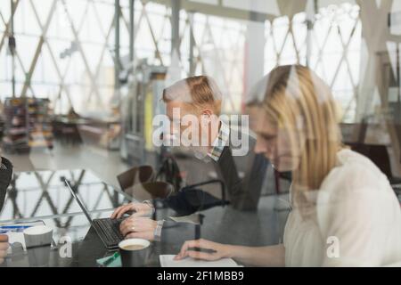 Mitarbeiter, die sich im Flughafencafé treffen Stockfoto
