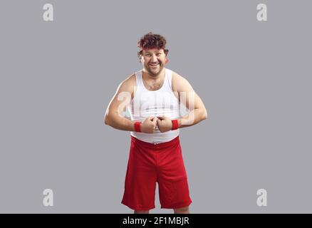Glücklicher Mann in Tank Top und Shorts lächelnd und biegsam Seine Arme zeigen seine Muskeln Stockfoto
