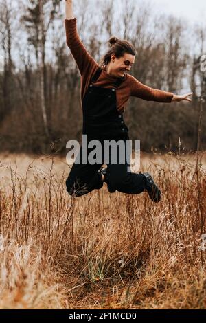 Glückliche Frau, die auf der Wiese springt Stockfoto