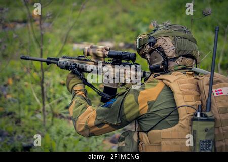 Eine Seitenansicht eines Soldaten der Spezialeinheiten, der mit dem Ziel anvisiert Ein Sturmgewehr Stockfoto