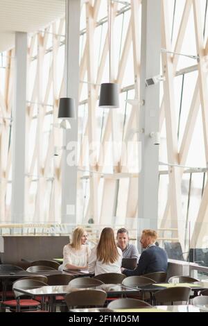Mitarbeiter, die sich im Flughafencafé treffen Stockfoto