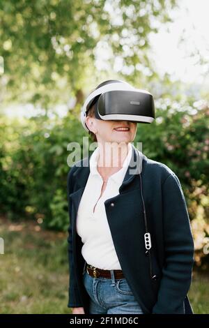 Frau im Park mit VR-Headset Stockfoto