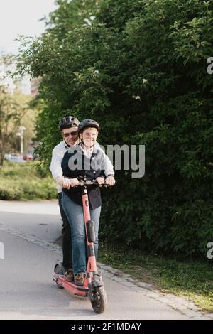 Ältere Paar Reiten Elektroroller im Park Stockfoto