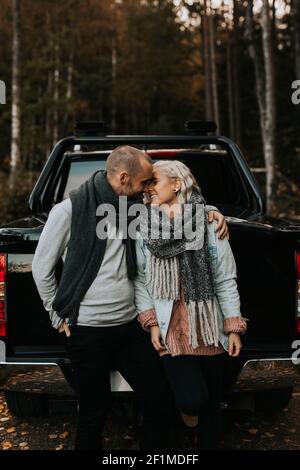 Ein Paar umarmt sich vor dem Auto Stockfoto