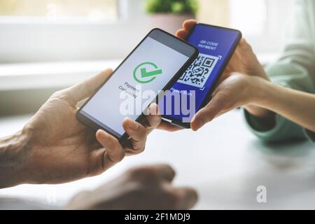 qr-Code Zahlung - Person mit Handy bezahlen Stockfoto