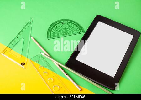Schulbüro Zubehör und elektronischer Buchleser mit leerem Bildschirm Für den Kopierbereich auf einem farbigen Hintergrund Stockfoto