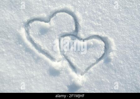 Das Symbol von zwei Herzen auf den Schnee gezeichnet, an einem sonnigen Wintertag. Romantik. Valentinstag. Speicherplatz kopieren. Stockfoto