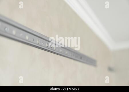 Nahaufnahme der Edelstahl-Montageschiene zur Montage von Küchenschränken an einer Wand. Stockfoto