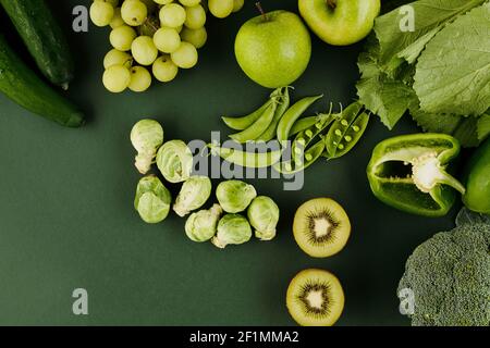 Grünes Obst und Gemüse auf dem Tisch wie Kiwi, Äpfel Erbsen, Trauben, Pfeffer und rosenkohl Stockfoto