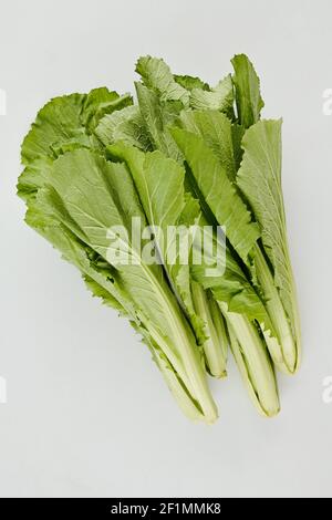 Stapel von grünen saftigen knackigen Salatblättern auf hellgrauem Hintergrund, Blick von oben Stockfoto