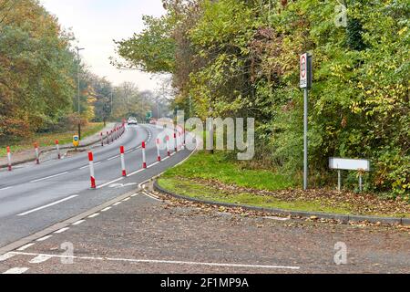 Zeigt ein Auto auf einer von Bäumen gesäumten Straße mit den neuen Pop-up-Fahrradrouten um Leicester City. Stockfoto