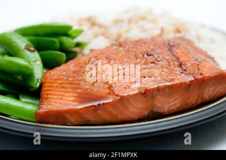 Lachsfilet mit weißem Reis, Erbsen und Ahornsoja-Glasur Stockfoto