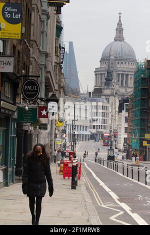 Leere und ruhige Fleet Street mit St. Pauls Cathedral im Hintergrund, London UK, während des Coronavirus, covid-19, Lockdown in England, Großbritannien, mit geschlossenen Büros und Geschäften und Fußgängern mit PSA-Masken Stockfoto