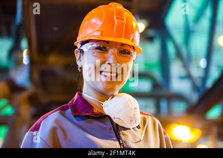 Koktau, Provinz Aktobe, Kasachstan - 06. Mai 2012: Golderzbergbau und -Verarbeitung, Konzentrationsanlage. Asiatische Arbeiterfrau in orangefarbenem Hardhat Stockfoto