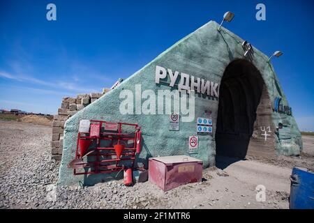 Khromtau, Region Aktobe, Kasachstan - Mai 06 2012: Portal der Golderzmine. Titel: Steinbruch (links) und Mechel Firmenlogo (rechts). Rote Feuerwehrleute Werkzeuge A Stockfoto