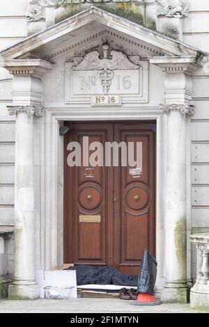 Obdachloser Mann während der Coronavirus Covid-19 Pandemiesperre, schlafen rau in der Tür am Waterloo Place London Stockfoto
