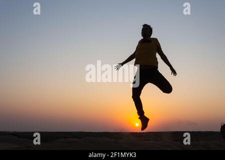 Silhouette einer Gruppe von Freunden, die während der Sonnenuntergangszeit glücklich springen, Rajasthan, Indien. Stockfoto