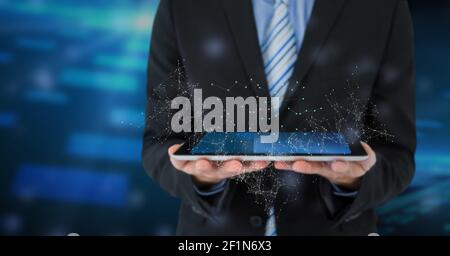 Netzwerk von Verbindungen und mittleren Abschnitt des Geschäftsmannes Holding digital Tablett vor blauem Hintergrund Stockfoto