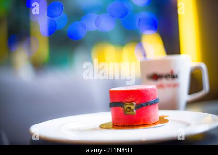 Eine kerzenartige Torte, für die Weihnachtszeit mit einer Tasse im Hintergrund Stockfoto