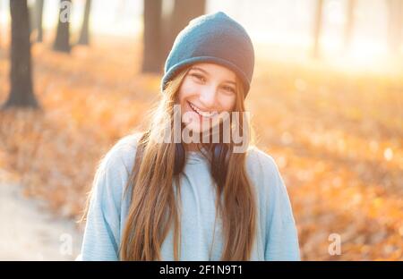 Glückliches Mädchen mit Kopfhörern im Herbst Park Stockfoto