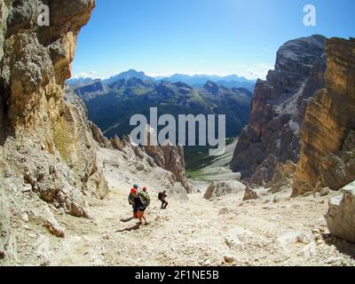 Gruppe von Bergsteigern auf einem steilen Geröll und Felsen Abstieg in den italienischen Dolomiten in Alta Badia Stockfoto