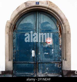 Detailansicht einer großen blauen gewölbten Holztür mit Ein Schild auf Französisch mit der Aufschrift "No Parking" vor dem Hotel Stockfoto